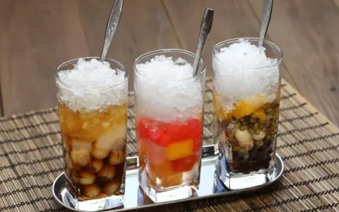 Drei Gläser mit Eis und bunten Zutaten, ein erfrischendes vietnamesisches Che.