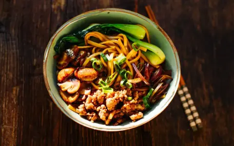 Schüssel mit Nudeln, Hackfleisch, Pilzen, Pak Choi und Zwiebeln – ein Beispiel für schnelle japanische Gerichte.