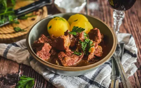 Herzhaftes Kalbsgulasch mit Kartoffeln, garniert mit Petersilie. Ein Festmahl, das man sich nicht entgehen lassen sollte – das beste Kalbsgulasch!