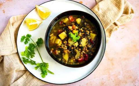 Herzhafte mangold suppe arabisch mit Linsen, Kartoffeln und Koriander. Serviert mit Zitronenspalten.