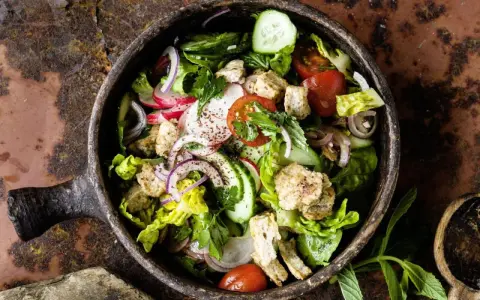 Frischer Fattoush Salat mit knackigem Gemüse, geröstetem Brot und Kräutern in einer rustikalen Schale. Ein tolles Fattoush Rezept!
