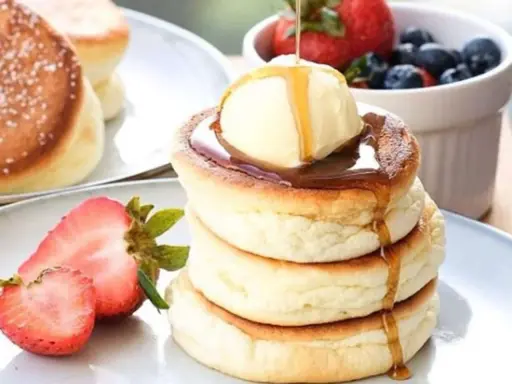 Fluffige japanische Pancakes mit einer Kugel Eis, Sirup und frischen Beeren. Ein Traum zum Frühstück!