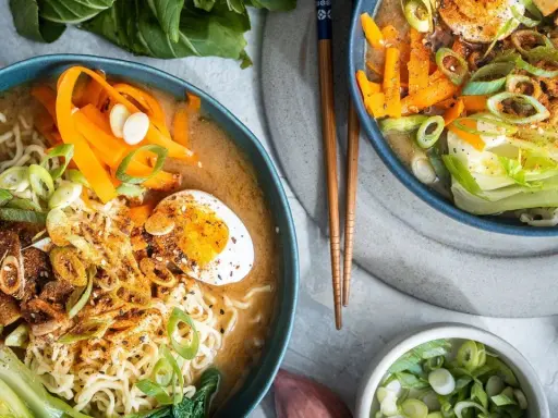 Zwei Schüsseln Miso Ramen mit Nudeln, Ei, Karotten, Pak Choi und Tofu. Ein leckeres miso ramen recipe.
