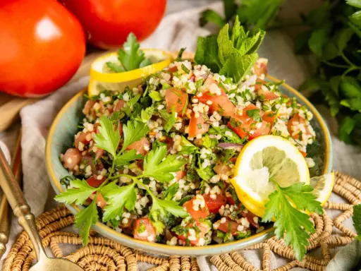 Frischer Tabbouleh Salat, ein authentisches Rezept, garniert mit Petersilie und Zitrone. Perfekt für ein leichtes Mittagessen.