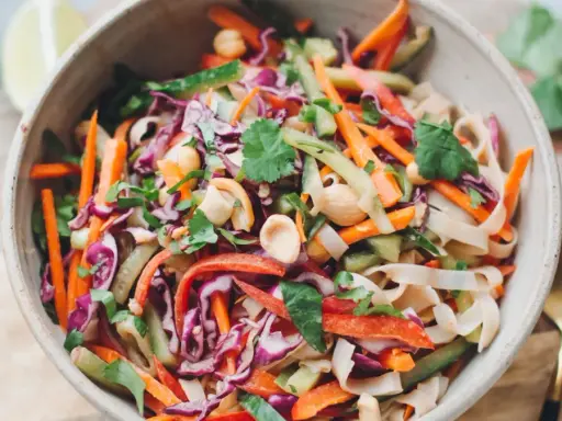 Bunter Reisnudelsalat mit Karotten, Rotkohl, Gurke und Erdnüssen. Ein frisches Rezept für heiße Tage.
