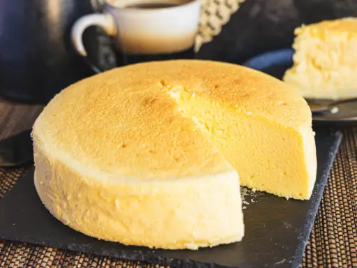 Fluffiger japanischer Käsekuchen, perfekt für Ihr nächstes japanisches Cheesecake-Rezept. Ein Stück ist bereits angeschnitten.