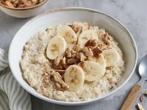 Cremiger Porridge mit Bananenscheiben, Nüssen und Zimt – ein leckeres Porridge Rezept mit Banane für einen guten Start in den Tag.