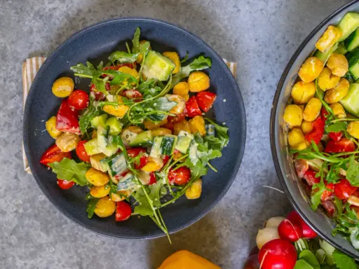 Knuspriger Gnocchi Salat aus dem Airfryer mit Tomaten, Gurken und Rucola, verfeinert mit einem cremigen Dressing.