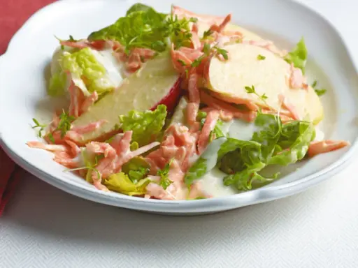 Erfrischender karotten apfel-salat mit joghurt und knackigem Salat, garniert mit Kresse.