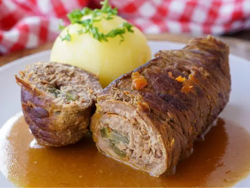 Zwei Rinderrouladen mit Kartoffelklößen und Soße. Was sind Rouladen? Gefüllte Fleischröllchen, ein Klassiker der deutschen Küche.