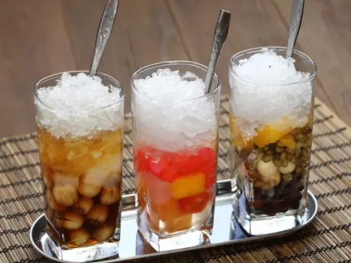 Drei Gläser mit Eis und bunten Zutaten, ein erfrischendes vietnamesisches Che.