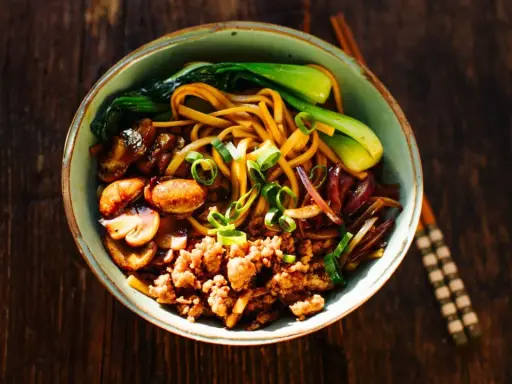 Schüssel mit Nudeln, Hackfleisch, Pilzen, Pak Choi und Zwiebeln – ein Beispiel für schnelle japanische Gerichte.