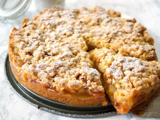 Omas weltbester Apfelkuchen, goldbraun gebacken mit knuspriger Streuseldecke und saftigen Äpfeln. Ein Stück Glück!