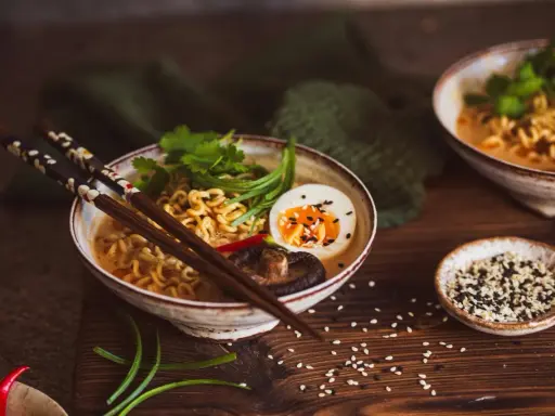 Herzhaftes vegetarisches Ramen mit Nudeln, Ei, Pilzen und frischen Kräutern, bereit zum Genießen.