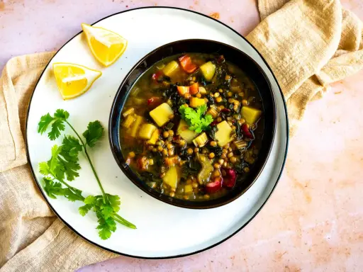 Herzhafte mangold suppe arabisch mit Linsen, Kartoffeln und Koriander. Serviert mit Zitronenspalten.
