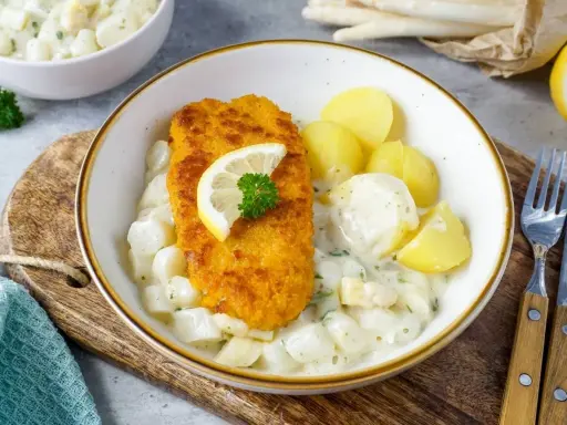Knuspriges Schnitzel auf Spargelgemüse mit Salzkartoffeln. Ein leckeres Gericht für Spargel Rezepte Mittagessen.