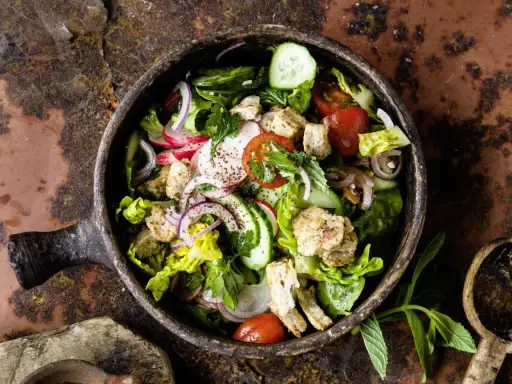 Frischer Fattoush Salat mit knackigem Gemüse, geröstetem Brot und Kräutern in einer rustikalen Schale. Ein tolles Fattoush Rezept!