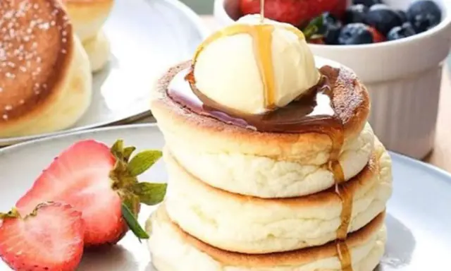 Fluffige japanische Pancakes mit einer Kugel Eis, Sirup und frischen Beeren. Ein Traum zum Frühstück!