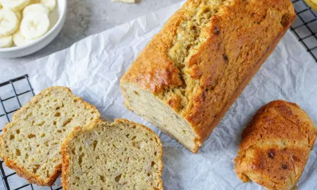Goldbraunes Bananenbrot, frisch gebacken, mit geschnittenen Scheiben daneben. Ein gesundes Bananenbrot Rezept zum Genießen.