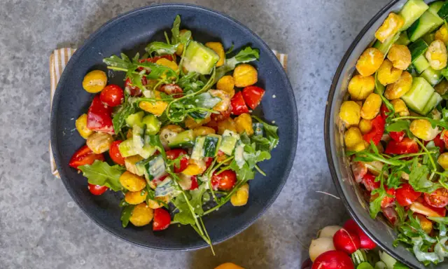 Knuspriger Gnocchi Salat aus dem Airfryer mit Tomaten, Gurken und Rucola, verfeinert mit einem cremigen Dressing.