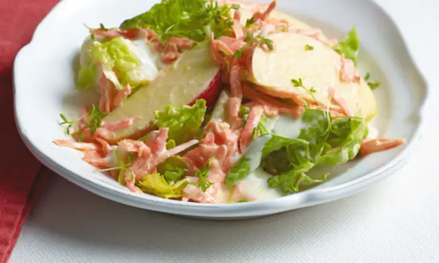 Erfrischender karotten apfel-salat mit joghurt und knackigem Salat, garniert mit Kresse.