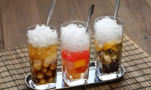 Drei Gläser mit Eis und bunten Zutaten, ein erfrischendes vietnamesisches Che.