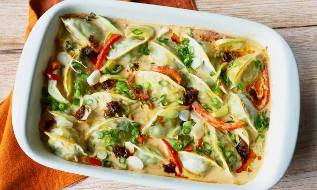 Gyoza in cremiger Sauce mit Paprika und Frühlingszwiebeln, eine köstliche Beilage.