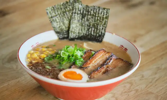 Herzhaftes Miso Ramen mit zartem Schweinebauch, Mais, Frühlingszwiebeln, Ei und Nori-Algen.