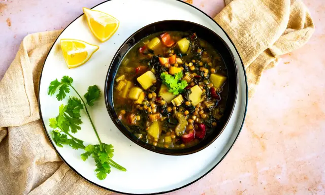 Herzhafte mangold suppe arabisch mit Linsen, Kartoffeln und Koriander. Serviert mit Zitronenspalten.