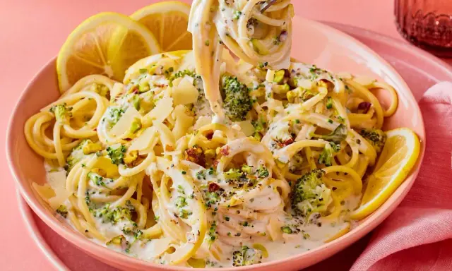 Cremige Pasta mit Brokkoli, garniert mit Pistazien und Zitronenspalten. Ein köstliches italienisches Gericht, das Lust auf mehr macht.