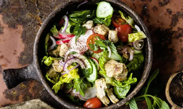 Frischer Fattoush Salat mit knackigem Gemüse, geröstetem Brot und Kräutern in einer rustikalen Schale. Ein tolles Fattoush Rezept!