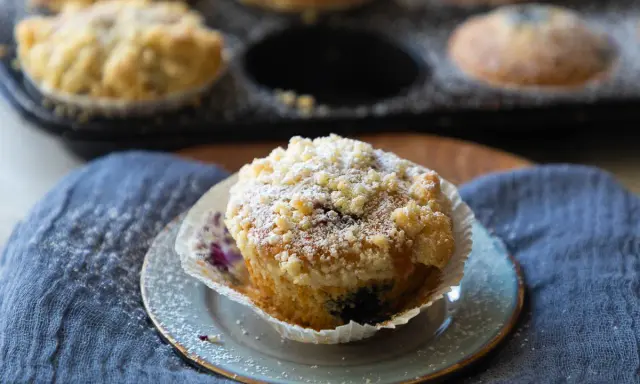 Saftige Blaubeermuffins mit Joghurt und Streuseln, bestäubt mit Puderzucker. Ein Genuss für jeden Kaffeetisch.