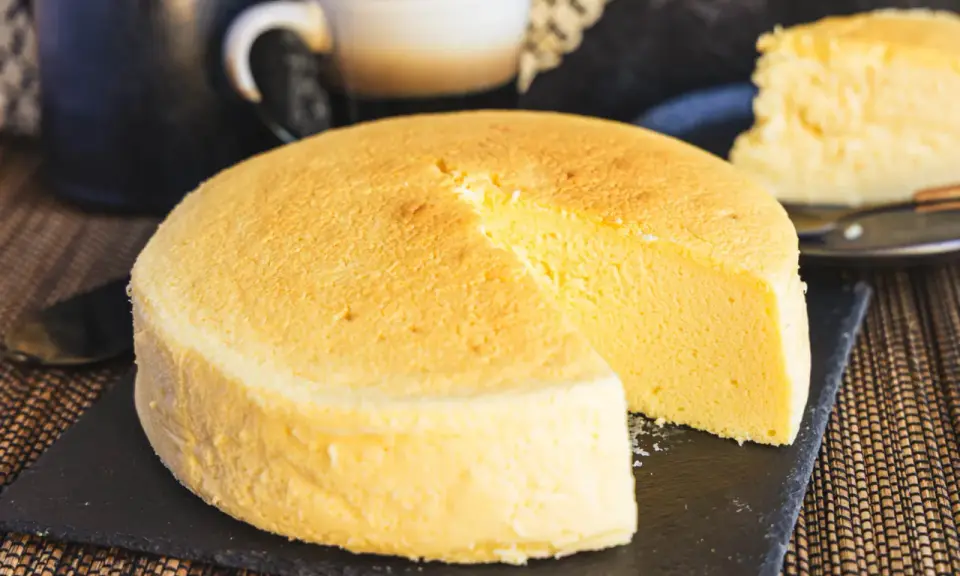 Fluffiger japanischer Käsekuchen, perfekt für Ihr nächstes japanisches Cheesecake-Rezept. Ein Stück ist bereits angeschnitten.