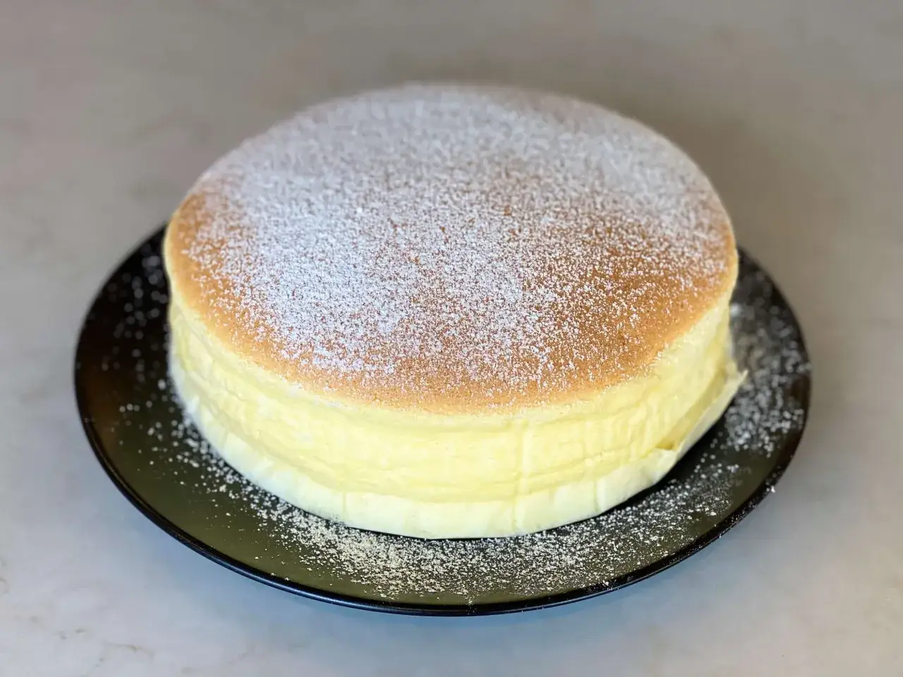 Fluffiger japanischer K&auml;sekuchen, best&auml;ubt mit Puderzucker. Ein perfektes Ergebnis nach diesem japanischen K&auml;sekuchen Rezept.