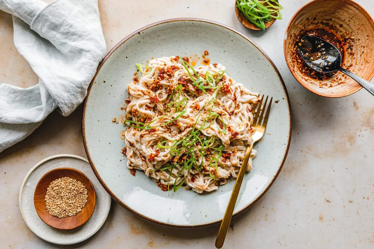 Nudeln mit cremiger Soße, garniert mit Frühlingszwiebeln und Chili-Flocken. Ein einfaches silken tofu recipe, das köstlich aussieht.