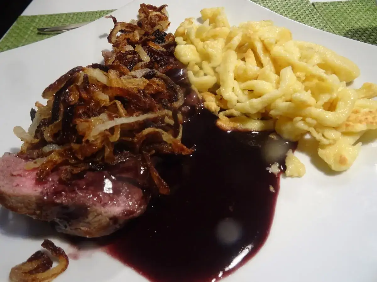 Ein saftiges Stück Fleisch mit dunkler Sauce, knusprigen Zwiebeln und Spätzle – das ist der beste Zwiebelrostbraten!