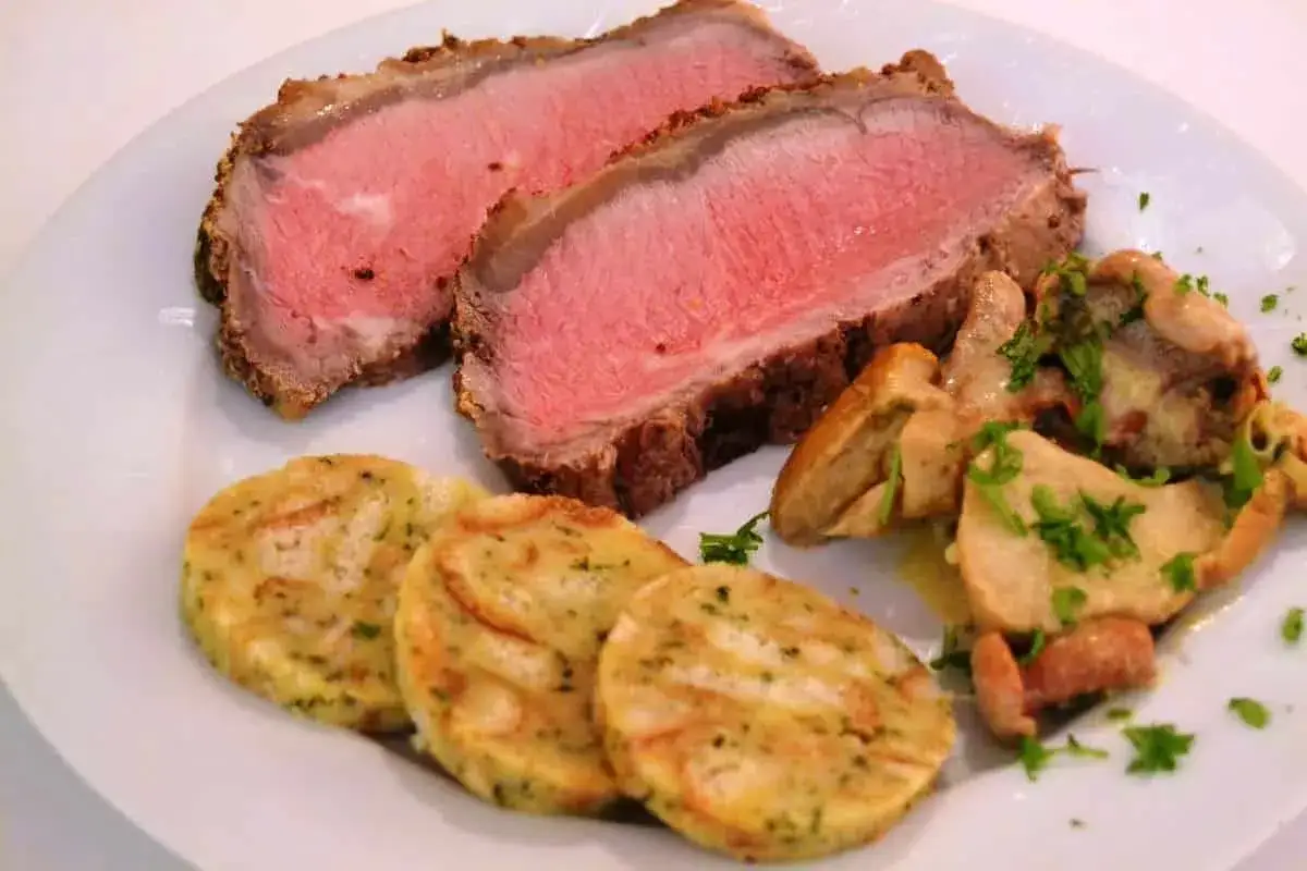 Zartes Roastbeef, perfekt rosa gebraten, serviert mit Semmelknödeln und Pilzen. Ein klassisches Roastbeef Rezept.