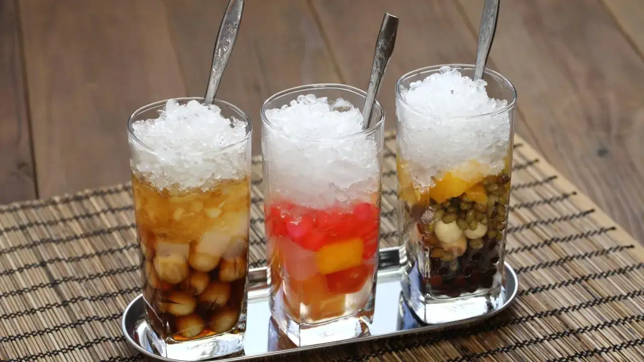 Drei Gläser mit Eis und bunten Zutaten, typisch für che vietnam. Erfrischende Süßspeisen.