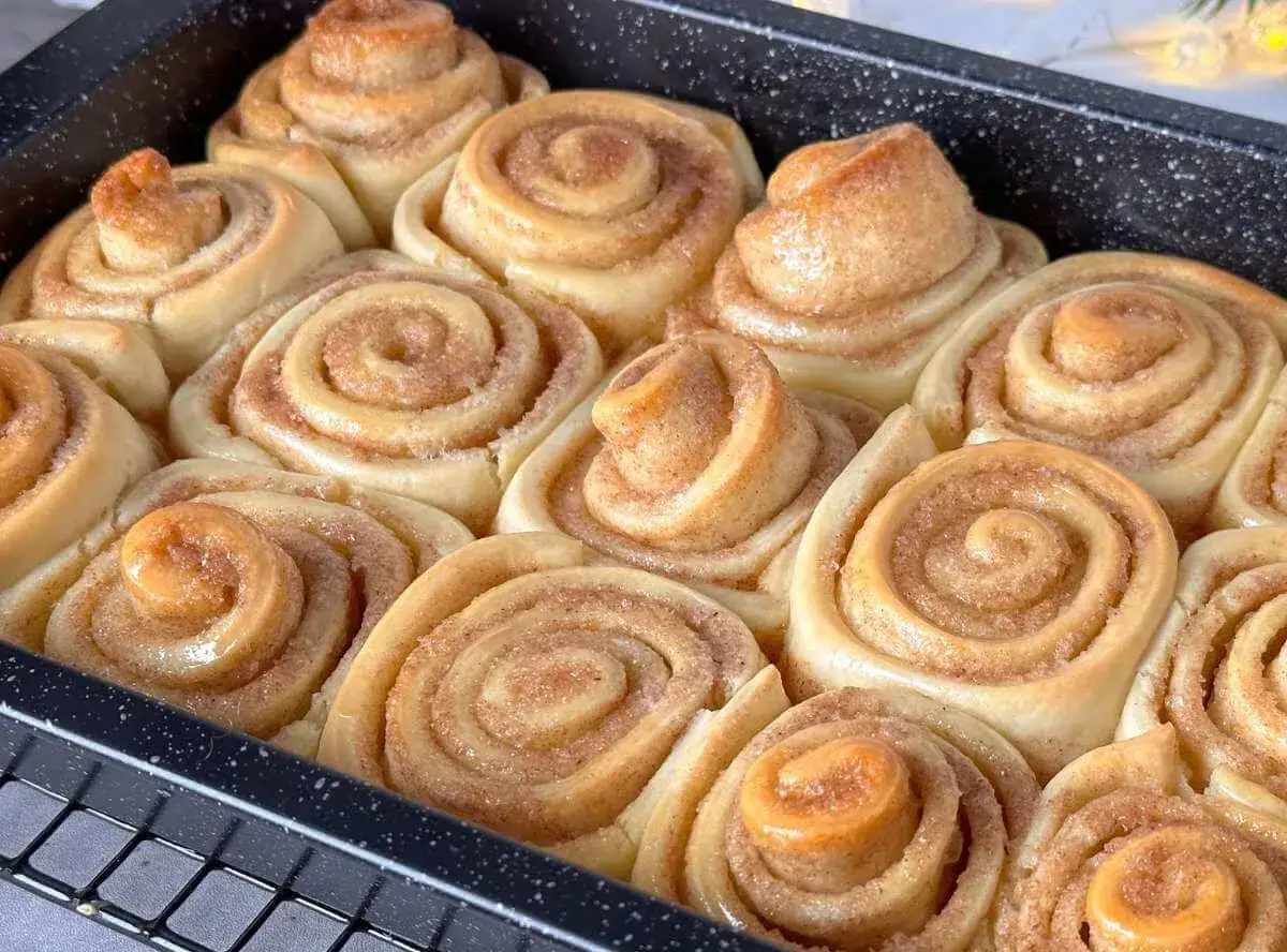 Frisch gebackene, fluffige Zimtschnecken in einer Backform. Sie duften nach Zimt und Zucker und sind bereit zum Genie&szlig;en.