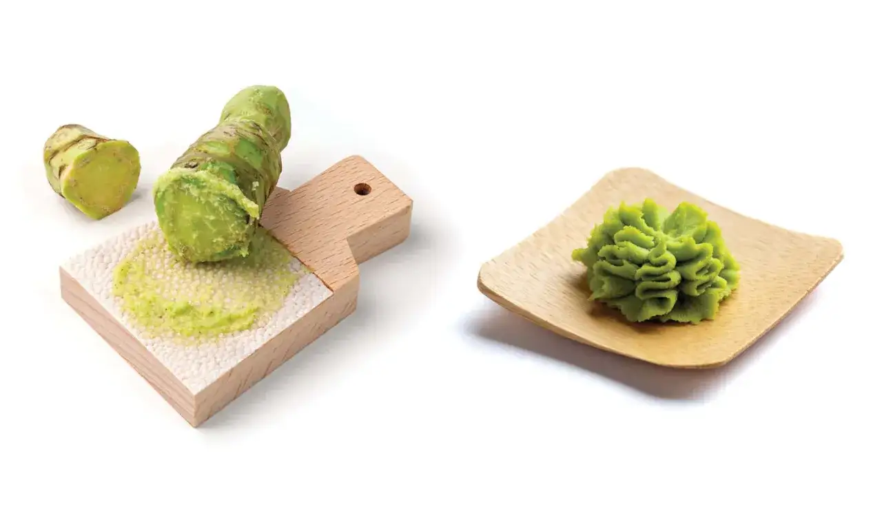 Frisch geriebener Wasabi auf einem Holzbrett und eine kunstvoll geformte Portion Wasabi auf einem kleinen Holztablett. Ist Wasabi gesund? Ja, er ist reich an Vitaminen und Mineralstoffen.