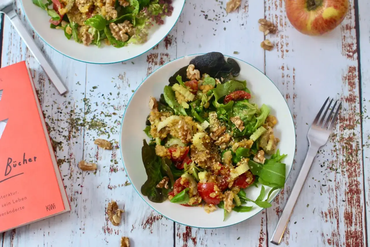 Ein k&ouml;stlicher Linsensalat mit Staudensellerie, Waln&uuml;ssen und Kirschtomaten, serviert auf einem rustikalen Holztisch.