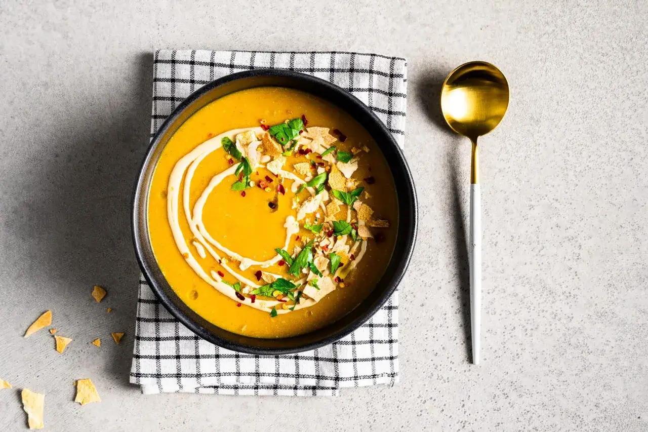 Eine cremige Mangoldsuppe, arabisch inspiriert, mit Tahini-Swirl, Kräutern und knusprigen Toppings.