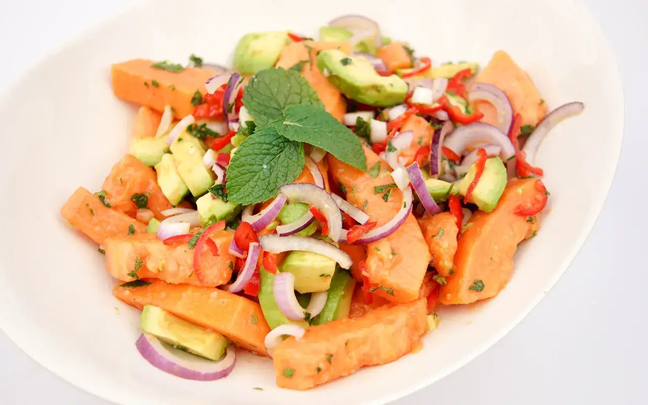 Frischer Papaya-Salat mit reifer Papaya, Avocado, roten Zwiebeln und Minze.