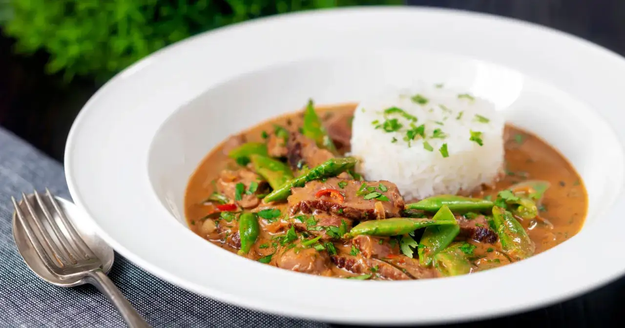 Ein k&ouml;stliches Thai Curry mit Rindfleisch, knackigen gr&uuml;nen Bohnen und duftendem Reis, garniert mit frischer Petersilie.