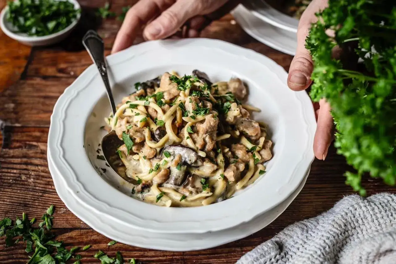 Herzhaftes Pilz-Bourguignon mit cremiger Sauce und frischer Petersilie, serviert auf einem Teller.