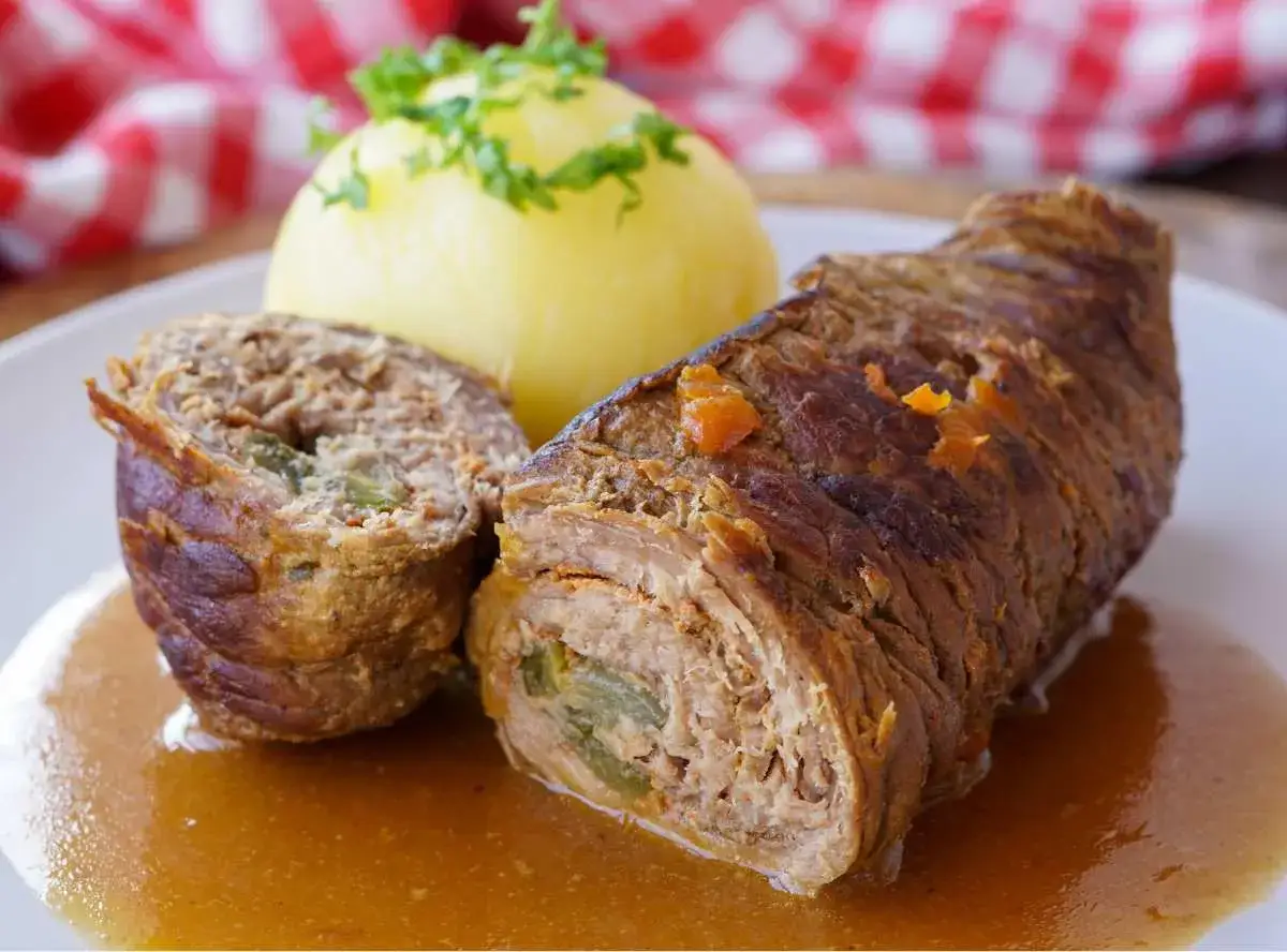 Zwei Rinderrouladen mit Kartoffelklößen und Soße. Was sind Rouladen? Gefüllte Fleischröllchen, ein Klassiker der deutschen Küche.