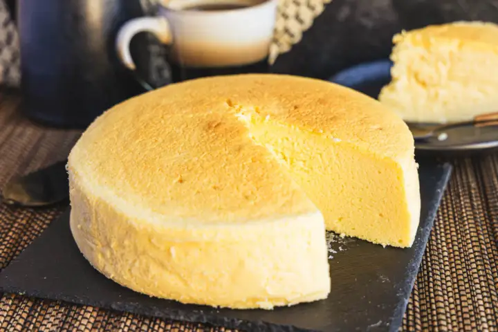 Fluffiger japanischer Käsekuchen, perfekt für Ihr nächstes japanisches Cheesecake-Rezept. Ein Stück ist bereits angeschnitten.